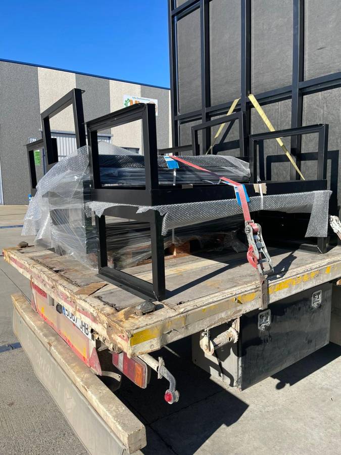 Contenedor marítimo modificado y paneles de acero en transporte