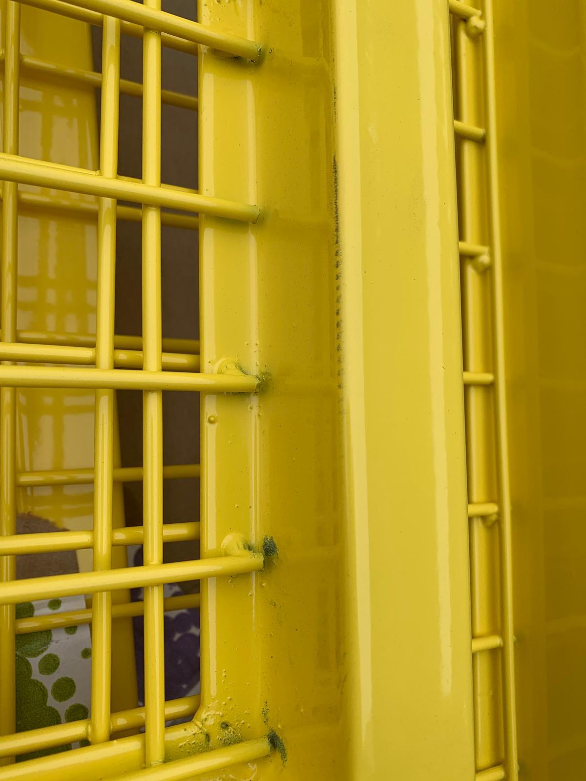 Detalle de rejilla industrial con marco tubular y soldadura de nudos electrosoldados en amarillo