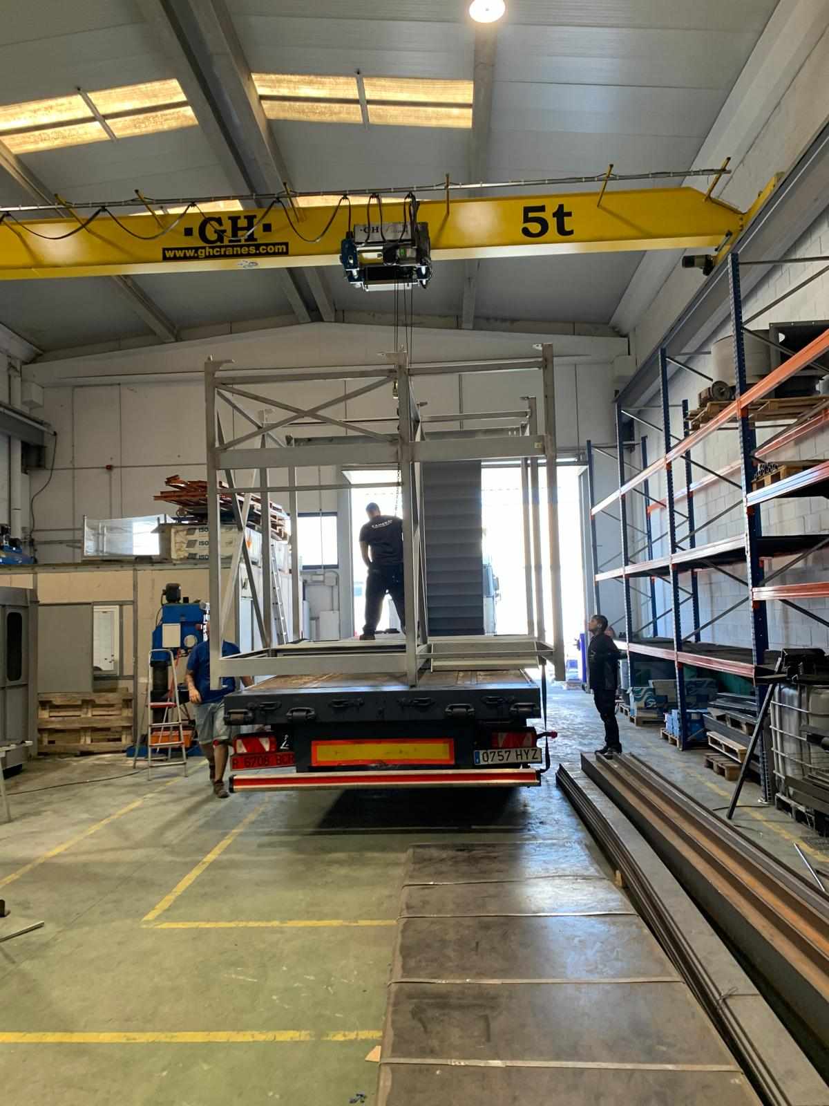 Plataforma metálica industrial con escalera cargada en camión desde el taller de Ingescam
