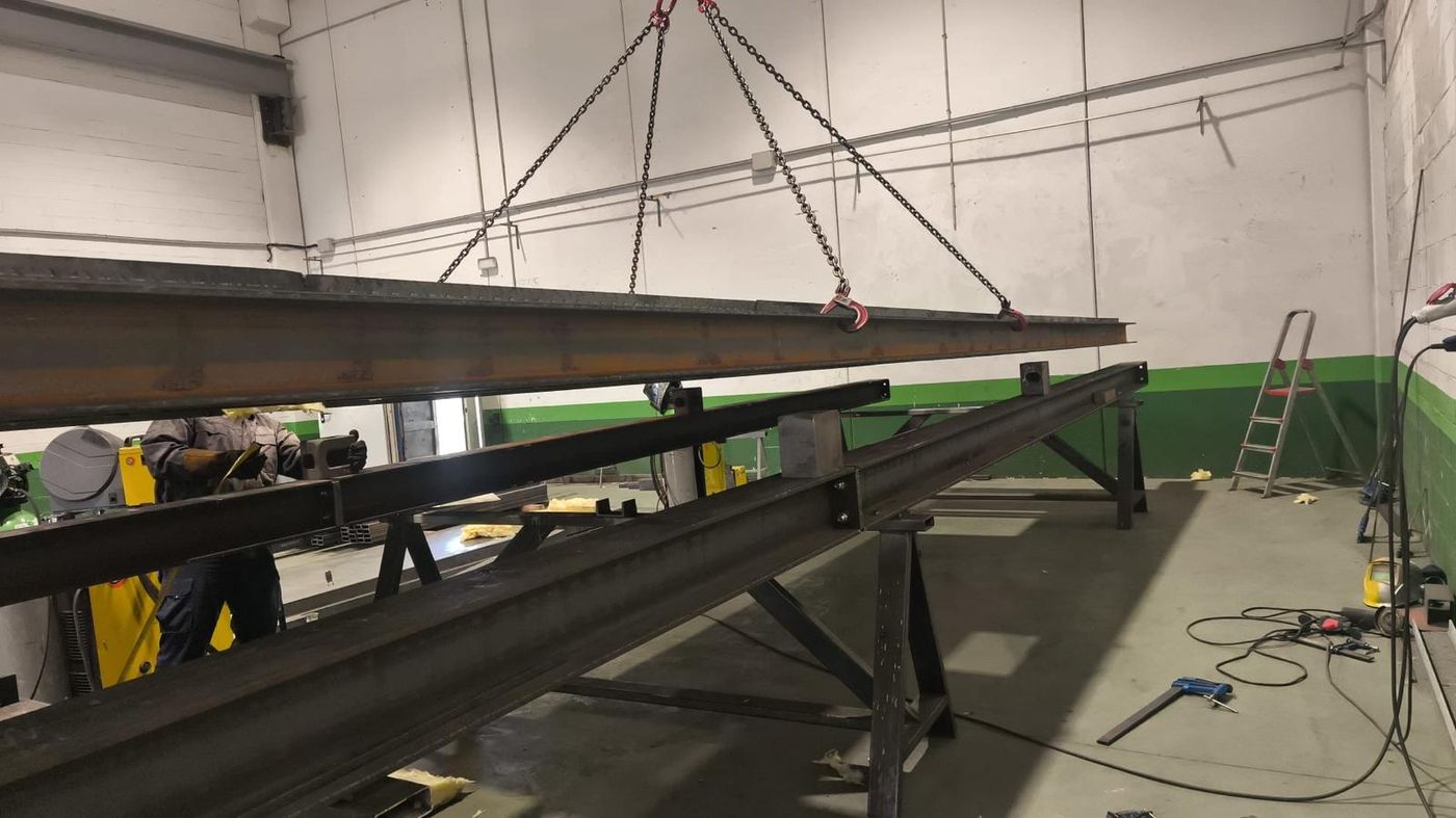 Vigas metálicas laminadas de gran perfil siendo manipuladas con puente-grúa en el taller de Ingescam